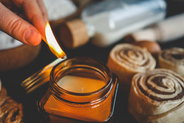 istock A hand lighting a candle in a cozy baking setup with cinnamon buns, flour, sugar, and eggs on a dark surface, ideal for warm kitchen scenes 2213923626