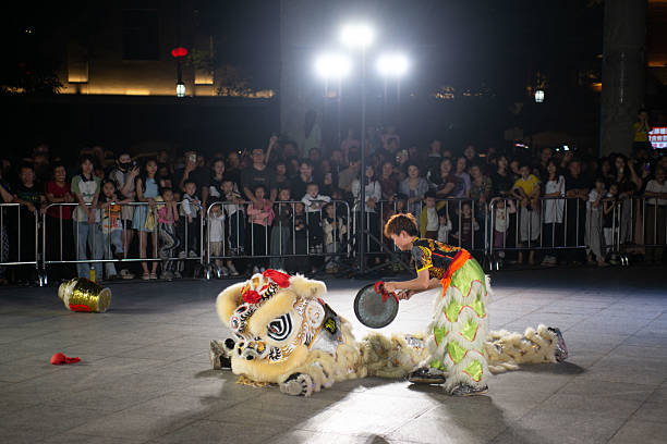 a drunk lion played by a teenager player in the series of Lion Dance performance in the downtown square in Jieyang, Guangdong, China a drunk lion played by a teenager player in the series of Lion Dancing performance in the downtown square in Jieyang, Guangdong, China chaozhou guangdong stock pictures, royalty-free photos & images