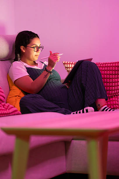 istock Pregnant woman working from home on sofa with tablet 2213923938