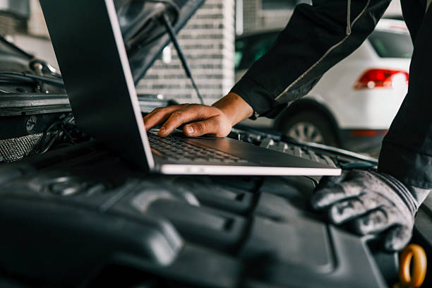 istock A mechanic using a laptop on a car engine for diagnostics in a garage. Highlights the use of technology in modern vehicle maintenance and repair 2213924755