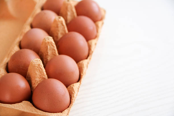 Close-Up Of Eggs In Carton Against White Background
