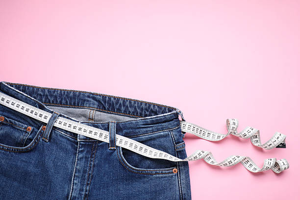 istock Jeans and measuring tape on pink background, top view. Space for text 2213925319
