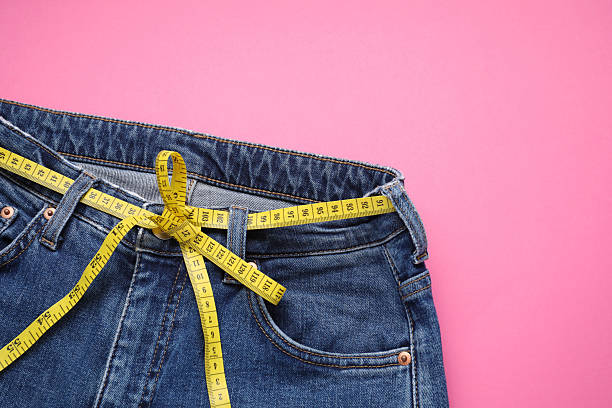 istock Jeans and measuring tape on pink background, top view. Space for text 2213925323
