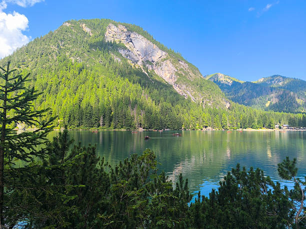 istock Majestic mountain landscape reflected in serene lake surrounded by lush green forest under a clear blue sky 2213926005