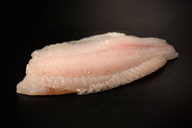 istock Fresh tilapia fillet on black background, top view. 2213929526