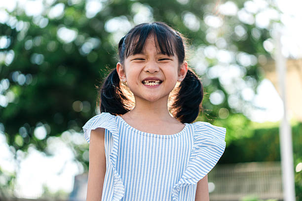 istock Smiling Girl with Missing Tooth Outdoors on Sunny Day 2213929809
