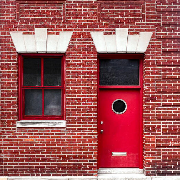 istock Red Brick Building with Porthole Door and Symmetrical Window 2213931029