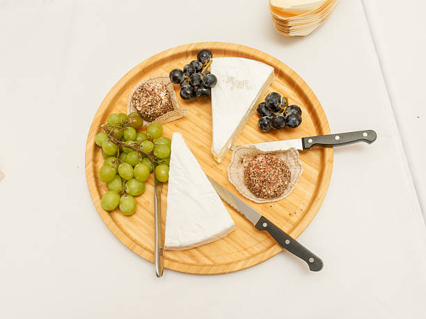 istock Heart-shaped cheese on a wedding cheese platter with grapes and utensils 2213932023