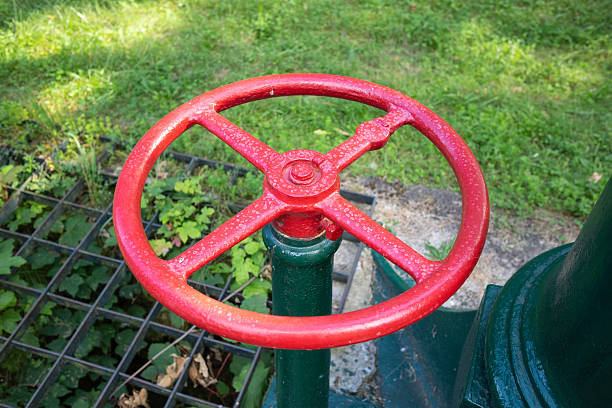 istock A red and black valve is sitting on a green pipe 2213935593