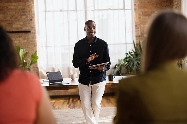 istock Young businessman leading a meeting with his team using a tablet in a modern office 2213936233