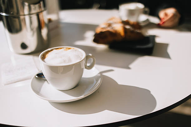 Cup of creamy cappuccino on the table in sunny day