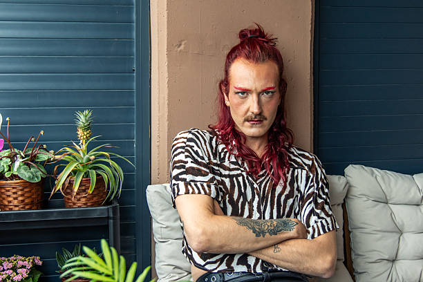 istock Young non-binary person with red hair and makeup posing with crossed arms 2213943063