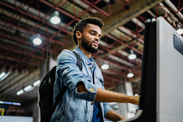 istock Mid adult man using self service check-in machine at the airport 2213943260