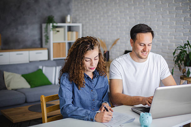 istock Young couple using laptop while planning their home budget 2213943586
