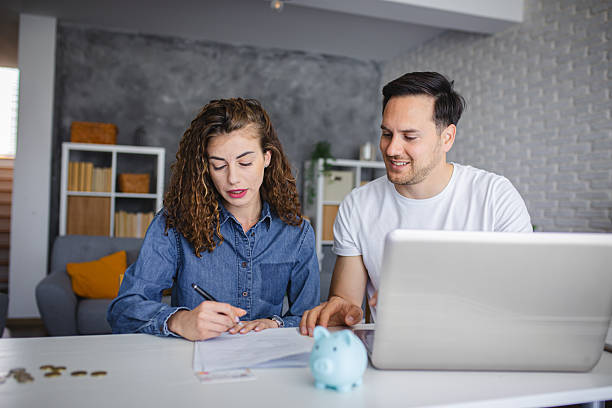 istock Young couple using laptop while planning their home budget 2213944135