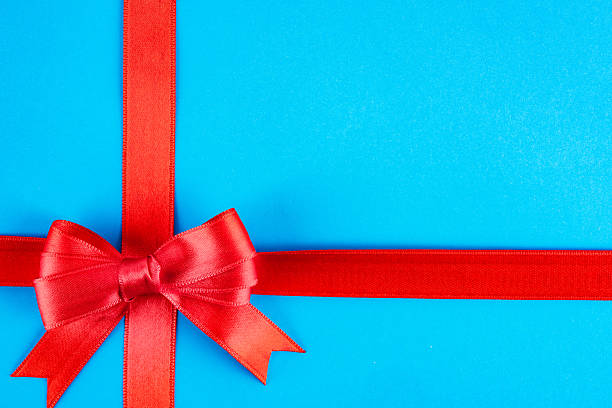 istock Red ribbon and bow on blue background 2213946188
