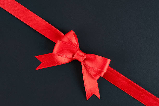 istock Red ribbon and bow on black background 2213946537