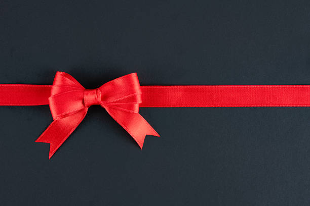 istock Red ribbon and bow on black background 2213947124