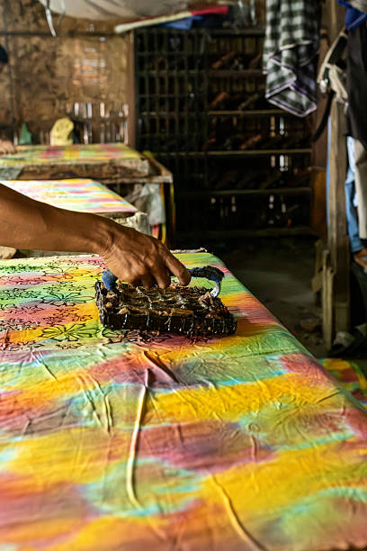 istock Artisan applying batik stamp on colorful fabric 2213947474