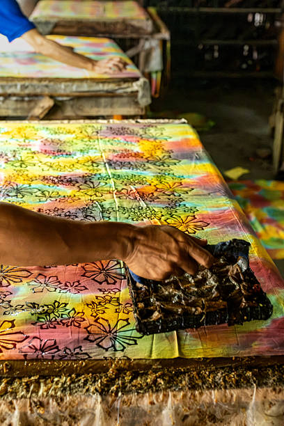 istock Artisan applying batik stamp on colorful fabric 2213949164