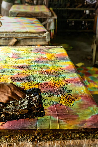 istock Artisan applying batik stamp on colorful fabric 2213949167