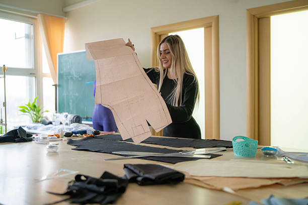 istock A skilled tailor is focused on her work, surrounded by various fabrics and sewing tools in a bright and organized workshop 2213950485