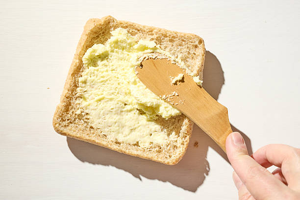 Spreading butter on bread with a butter knife.
