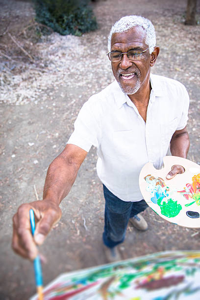 istock Senior black man painting in nature 2213954304