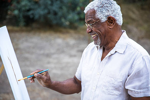 istock Senior black man painting in nature 2213954330