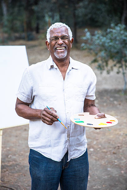 istock Senior black man painting in nature 2213954385