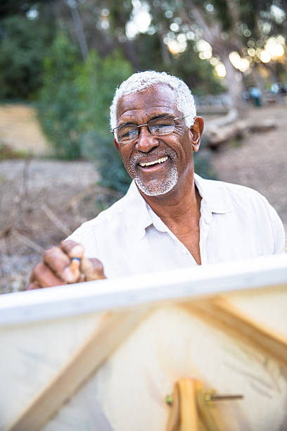 istock Senior black man painting in nature 2213954397