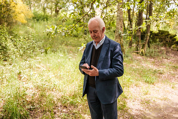 istock Senior businessman using a smartphone in a park 2213955226