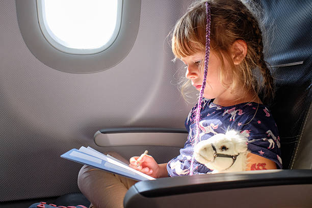 istock Child Drawing and Writing on Airplane During Flight Travel 2213955340