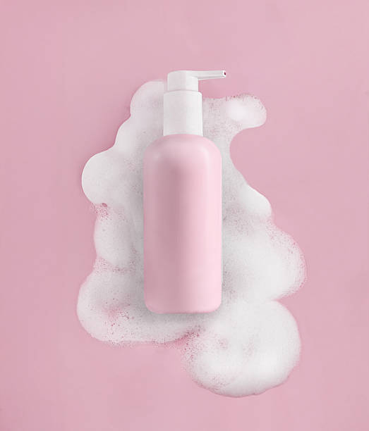 istock Elegant Pink Pump Bottle Beautifully Surrounded by Soft Cosmetic Foam 2213957192