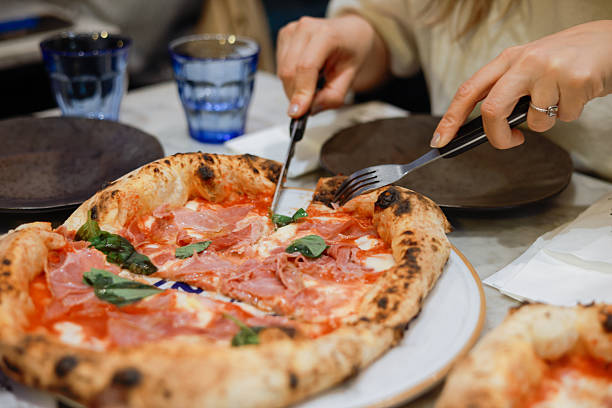 istock Unrecognizable woman eating pizza in restaurant 2213960361