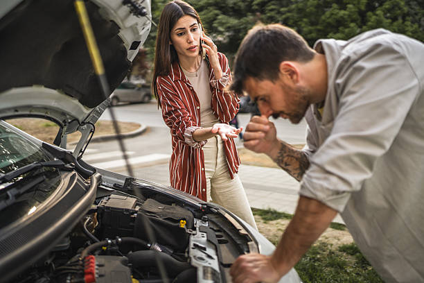 istock Boyfriend check car engine while girlfriend calls for assistance 2213963098