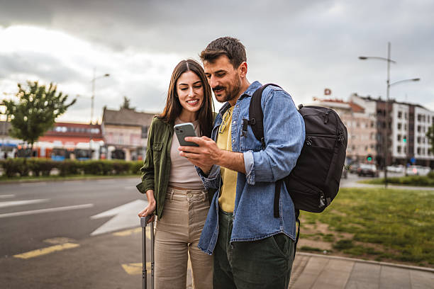 istock man and woman passengers use cellphone while wait bus on bus station 2213963851