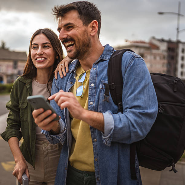 istock man and woman passengers use cellphone while wait bus on bus station 2213963908