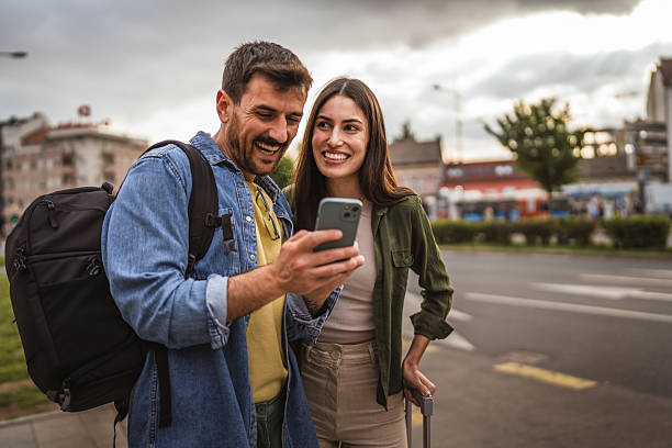 istock man and woman passengers use cellphone while wait bus on bus station 2213964472