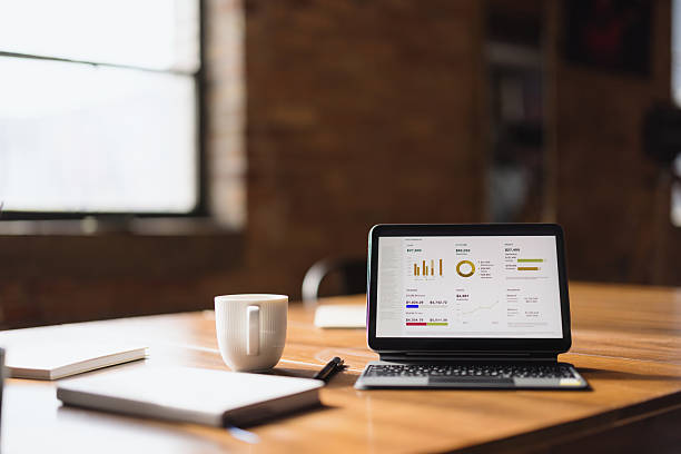 istock Laptop displaying financial charts and graphs on a wooden table 2213966197