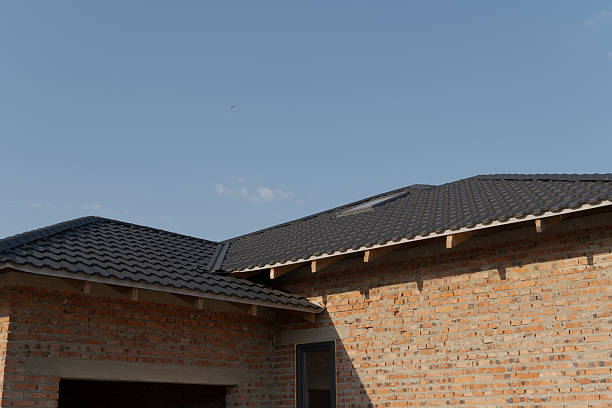 istock A contemporary home features a black shingled roof with a textured brick facade under a clear blue sky during daylight 2213968073