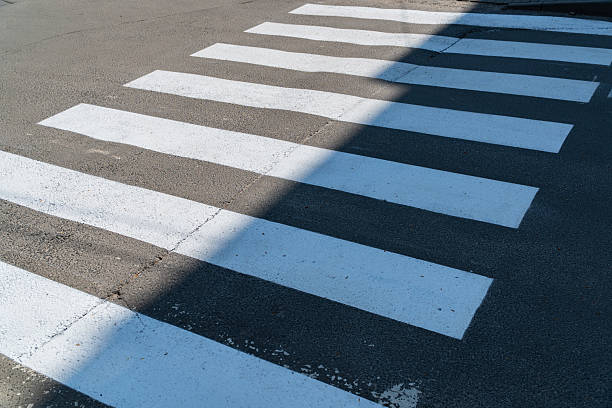 istock Crosswalk lines create a clear path for pedestrians in a city setting, illuminated by natural sunlight in late morning 2213968093