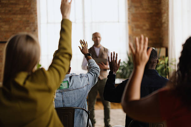 istock Students raising hands asking questions during seminar 2213968634