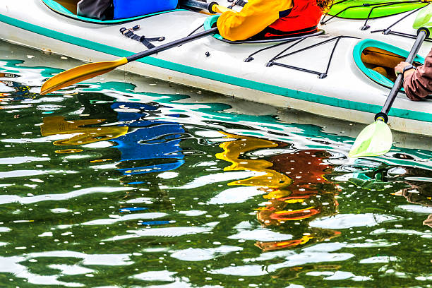 Family with children on rafting trip in Group kayak trip of different ages, adults, elderly. Rowing boat on the river, a water hike, summer adventure.