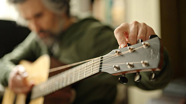 istock Musician Slackens Strings On His Acoustic Guitar, Close Up 2213972493