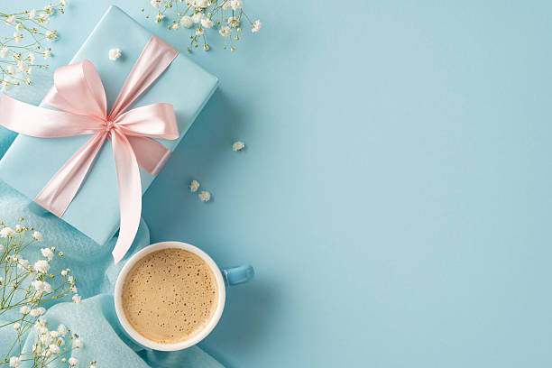 istock Pastel blue setting featuring a coffee mug, wrapped gift with ribbon, and delicate flowers 2213974280