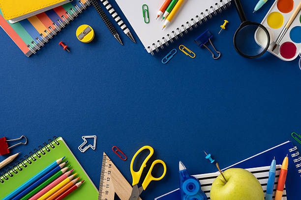 istock School supplies creatively arranged on a blue surface, including notebooks, pencils, scissors, and an apple. Ideal for educational themes, school concepts, academic environments, and presentations 2213974290