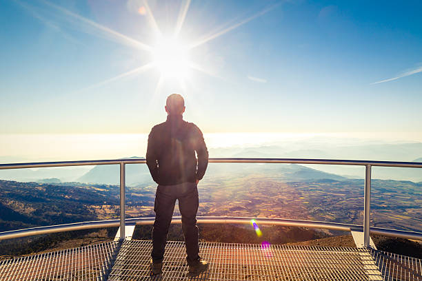 Hiker looking at pico de orizaba volcano from a viewpoint on sierra negra volcano in mexico