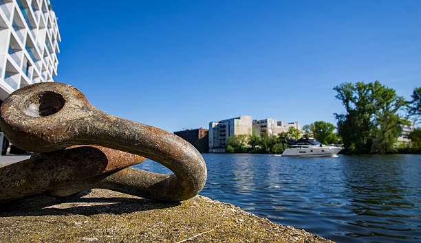 istock Iron Mooring Ring on the Spree River in Berlin with Passing Yacht on a Spring Day 2213976305