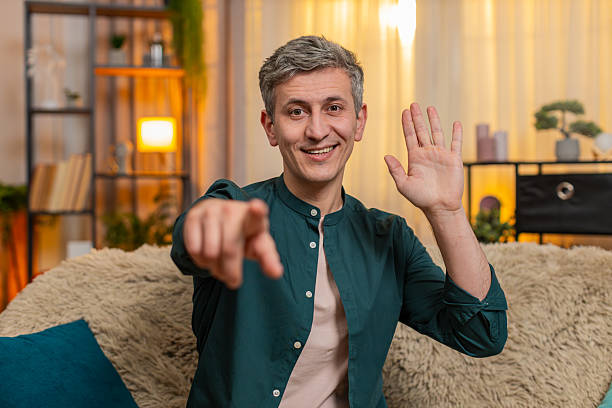 istock Man pointing at camera with excitement greeting hello friend during cheerful video conversation 2213980274
